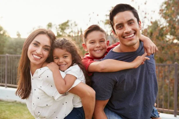 Familia latina feliz frente a su nueva casa en Australia